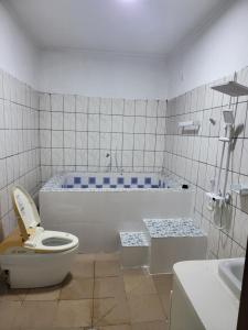 un baño con inodoro y bañera en Ndouha House, en Bafoussam 13 fotos más