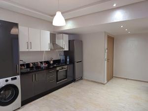 a kitchen with a black refrigerator and a washer at Apartment kamal park E21 in Mohammedia