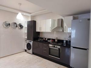 a kitchen with a refrigerator and a stove at Apartment kamal park E21 in Mohammedia +4 photos