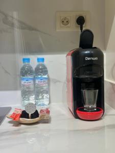 a coffee maker and two bottles of water on a counter at Modern Comfort Studio, la corniche in Mohammedia