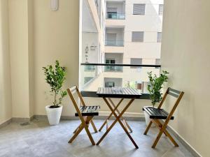 a table and two chairs in a room with a window at Modern Comfort Studio, la corniche in Mohammedia