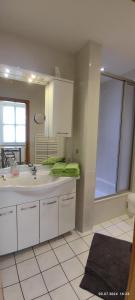 un bagno con un lavandino e una grande finestra di DIE HOTELALTERNATIVE DELUXE APP erste Etage mit 2 Schlafzimmer Haus 63 a Solingen