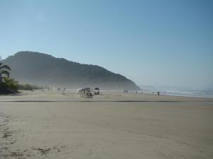 a group of people standing on a beach at Pousada Y-Goá in Bertioga