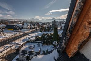 een uitzicht op een stad in de sneeuw vanuit een gebouw bij Osada Witów - apartament „Czerwone Wierchy” in Witów