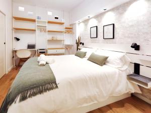 Un dormitorio con una gran cama blanca y estanterías en Increíble apartamento de lujo en Terrassa, en Terrassa