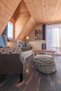 een woonkamer met een bank en een tafel bij Osada Witów - apartament „Niebieska Turnia” in Witów