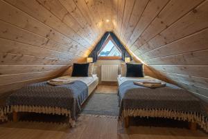 een kamer met 2 bedden in een boomhut bij Osada Witów - apartament „Niebieska Turnia” in Witów