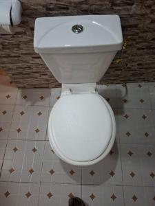 een badkamer met een wit toilet in een kamer bij Hôtel auberge Sankaranka in Abémé