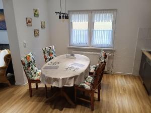una sala da pranzo con un tavolo e quattro sedie di Ferienwohnung 70 , Gersfeld Rhön , Ortsmitte , frisch saniert , Gästehaus Mierdel a Gersfeld