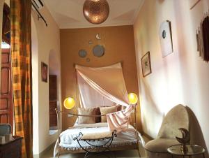 马拉喀什达特利文摩洛哥传统庭院住宅的带床和椅子的卧室