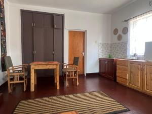 John's Place في أروشا: مطبخ مع طاولة وكراسي في الغرفة