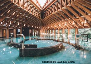 a large swimming pool in a large building at Charmant studio en Ardèche - village médiéval in Burzet