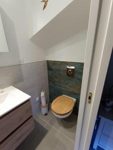 a bathroom with a wooden toilet and a sink at Charmant studio en Ardèche - village médiéval in Burzet