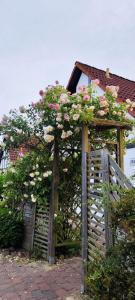 un cancello di legno con dei fiori accanto a una casa di Ruhiges Elbhäuschen nahe Hamburg a Hollern-Twielenfleth