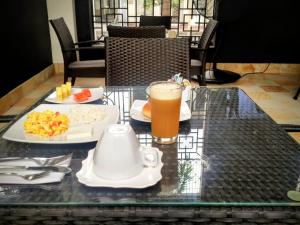 a glass table with food and a drink on it at Hotel Republicano 1910 in Girardot