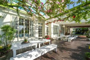 a conservatory with white benches and flowering plants at GREEN INN in Wujie