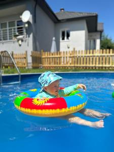 a young child in a pool on a raft at Family Apartments Myto pod Dumbierom in Mýto pod Ďumbierom