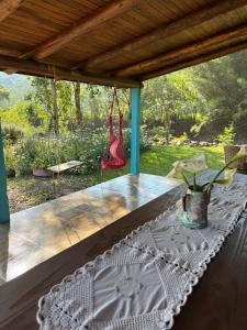a table on a porch with a hammock at Pousada dos Sonhos - Timbé do Sul in Timbe do Sul +21 photos