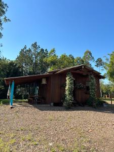 Cabaña de madera con mesa y sillas frente a ella en Pousada dos Sonhos - Timbé do Sul, en Timbe do Sul