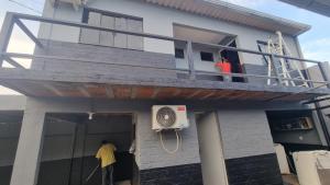 un hombre parado fuera de una casa con balcón en Kitnet, en Ponta Porã