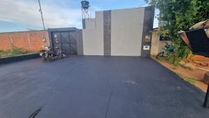 Un estacionamiento vacío con motocicletas estacionadas frente a un edificio. en Kitnet, en Ponta Porã