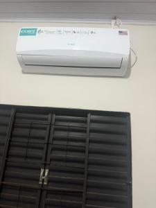 Un acondicionador de aire colgado en una pared junto a un respiradero. en Kitnet, en Ponta Porã