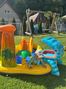 a child is laying on an inflatable toy on a play equipment at Family Apartments Myto pod Dumbierom in Mýto pod Ďumbierom