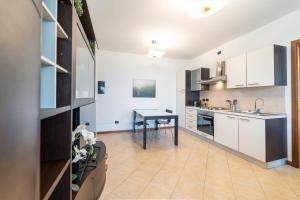 Una cocina con gabinetes blancos y una mesa. en Moderno appartamento con garage, Wi-Fi, aria condizionata e terrazzo, en Milán