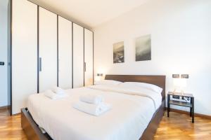 Un dormitorio con dos camas con sábanas blancas. en Moderno appartamento con garage, Wi-Fi, aria condizionata e terrazzo, en Milán