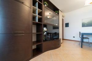 Un gran armario de madera en una sala de estar. en Moderno appartamento con garage, Wi-Fi, aria condizionata e terrazzo, en Milán