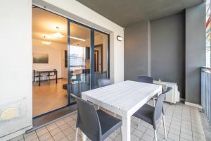 Un comedor con una mesa y sillas blancas. en Moderno appartamento con garage, Wi-Fi, aria condizionata e terrazzo, en Milán