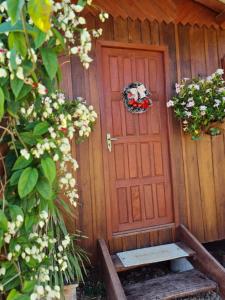 una puerta de madera con un banco delante en Pousada dos Sonhos - Timbé do Sul, en Timbe do Sul