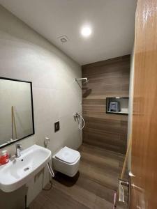 Un baño con lavabo, inodoro y espejo. en Atlantic view Tamraght, en Tamraght Ou Fella