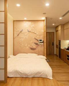 a bedroom with a bed with a painting on the wall at Sakura Room Ở Space Ecopark in Kim Quan +16 photos