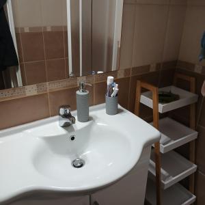a bathroom with a white sink and a mirror at Apartman Montis in Kupres +19 photos