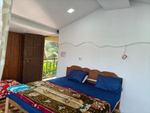 Un dormitorio con una cama y un balcón. en RivoGoa riverside Homestay, en Bardez 13 fotos más