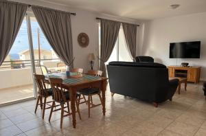 a living room with a table and chairs and a couch at Argaka Breeze sea view apartment in Argaka