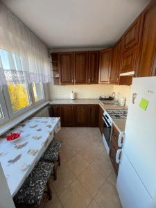 Apartament, mieszkanie 3-pokojowe في كوتنو: مطبخ مع طاولة وثلاجة بيضاء