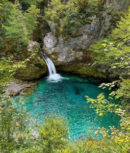 a waterfall in the middle of a pool of blue water at Kulla e Gjyshit - Guest House in Theth