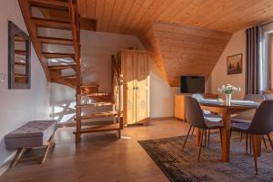 a living room with a table and a spiral staircase at Osada Witów - apartament „Siwa Kopa” in Witów