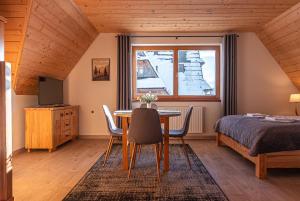 een slaapkamer met een eettafel en een bed bij Osada Witów - apartament „Siwa Kopa” in Witów