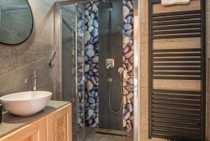 een badkamer met een douche met wastafel en spiegel bij Osada Witów - apartament „Siwa Kopa” in Witów