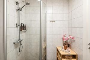 a shower stall in a bathroom with white tiles at Modern Suites, Excellent Location in the heart of Bergen in Bergen +24 photos