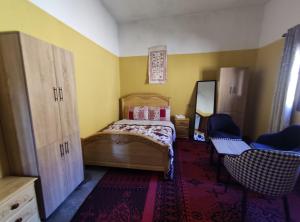 a small bedroom with a bed and two chairs at Asmaa Guesthouse Todra in Tinerhir