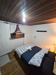 Pousada Nova Brasília Ilha do Mel في باراناغوا: غرفة نوم بها سرير وسقف خشبي