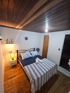 Pousada Nova Brasília Ilha do Mel في باراناغوا: غرفة نوم بها سرير وسقف خشبي
