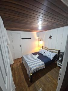 Pousada Nova Brasília Ilha do Mel في باراناغوا: غرفة نوم بها سرير وسقف خشبي