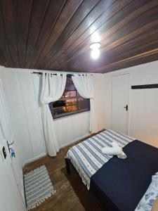 Pousada Nova Brasília Ilha do Mel في باراناغوا: غرفة نوم بها سرير ونافذة +صورتان