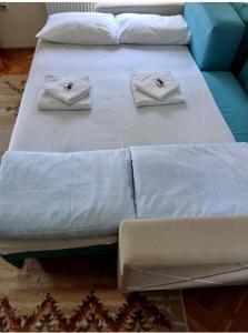 two beds with white sheets and towels on them at Apartman Bubamara in Arilje