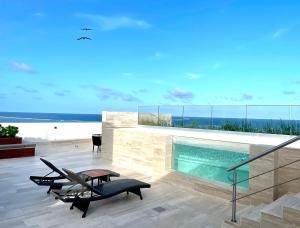 a house with a pool and a table and chairs at Estudio 104 en Distrito Puerto in Puerto Morelos
